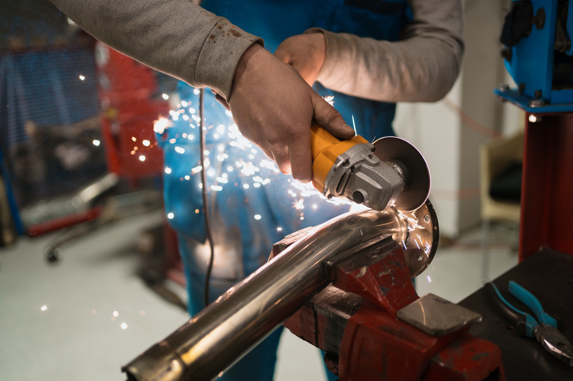Worker working with a circular grinder on a metal with sparks